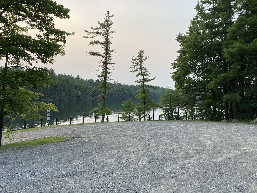 parking lot at Sixberry Lake Public boat Launch and fishing access with lake and trees in background