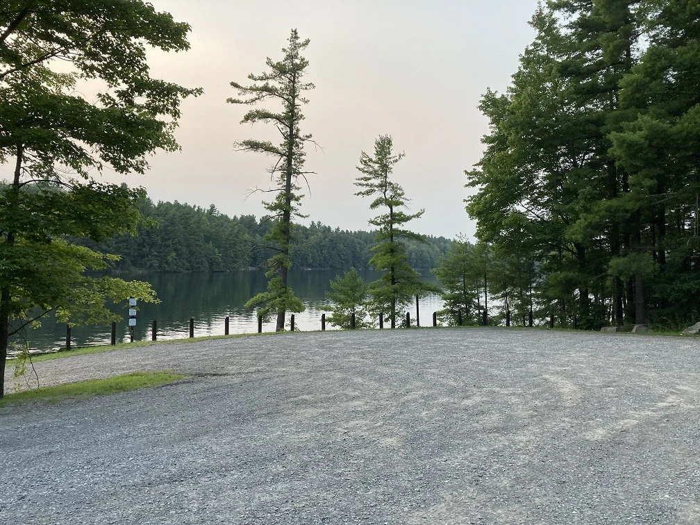 parking lot at Sixberry Lake Public boat Launch and fishing access with lake and trees in background