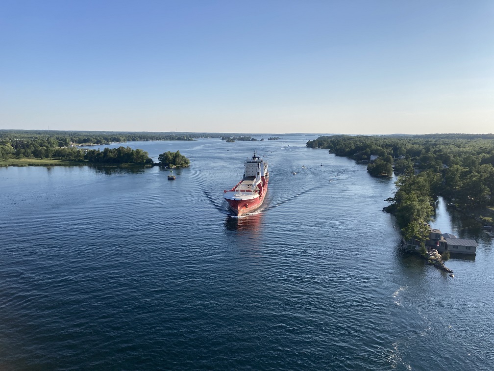 View of a large red and white cargo ship in the St. Lawrence River at Alexandria Bay, New York