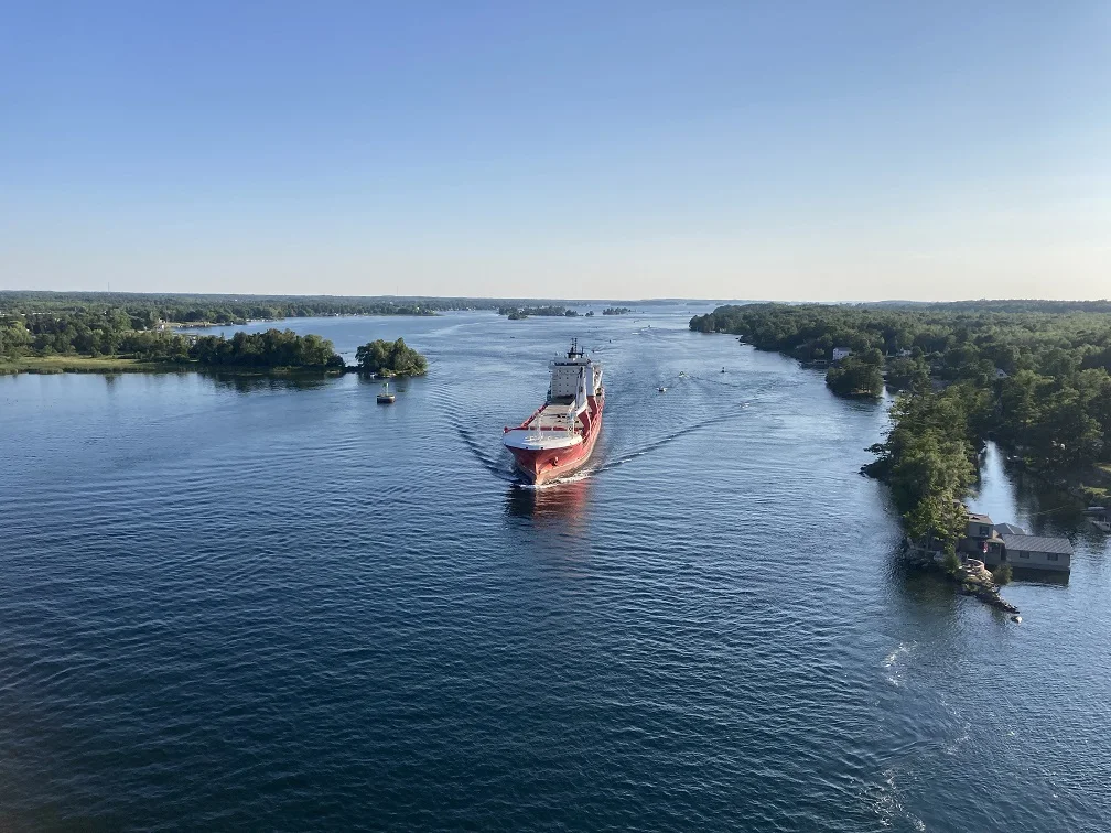 View of a large red and white cargo ship in the St. Lawrence River at Alexandria Bay, New York